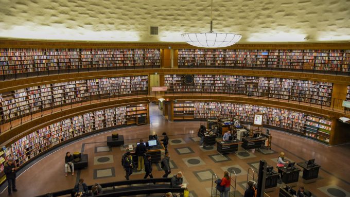 A spacious interior view of Stockholm Public Library, showcasing its circular design and bookshelves.