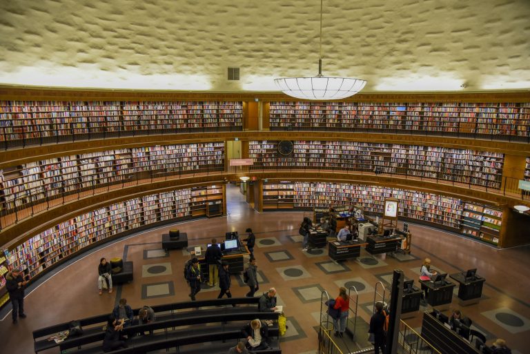 A spacious interior view of Stockholm Public Library, showcasing its circular design and bookshelves.